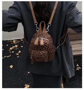 Mini leopard print backpack shown on model wearing a grey blazer in autumn outdoor setting
