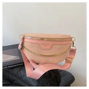 Détail du sac à bandoulière rose clair à motif crocodile avec chaîne dorée et fermeture éclair