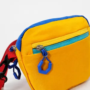 Close-up of multicolor nylon belt bag with blue geometric zipper pull and red strap