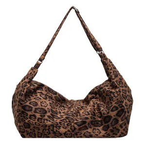 Retro leopard print tote bag with crescent shape and metallic hardware links on white background