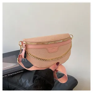 Détail de la texture crocodile rose, zip doré et chaîne sur le sac bandoulière demi-lune