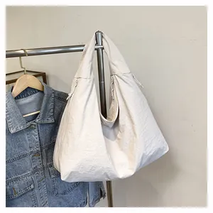 Dettaglio della grande borsa tote in nylon bianco crema con tessuto strutturato e coulisse