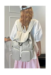 Dettaglio del grande zaino in nylon con chiusura a fibbia e tasche multiple con zip