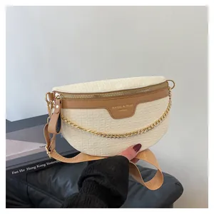 Détail de la texture motif crocodile et chaîne dorée sur ce sac bandoulière beige
