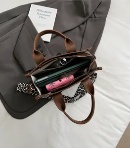 Geräumiger Innenraum einer braunen Lederhandtasche mit Leopardenriemen und Tablet-Fach