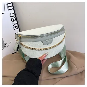 Détail du sac de poitrine vert menthe gaufré crocodile avec chaîne dorée et bandoulière