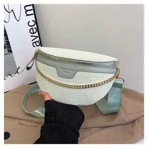 Détail du sac banane crème avec motif crocodile et chaîne en métal doré