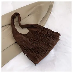 Dettaglio ravvicinato della borsa tote in pelle scamosciata marrone con frange lunghe boho