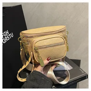 Dettaglio borsa beige con cerniere dorate, pelle martellata e ciondolo a lucchetto