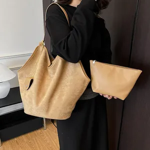 Vue détaillée du sac cabas en daim kaki et de sa pochette assortie sur un mannequin