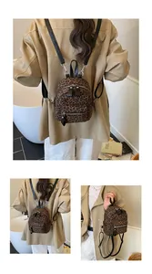 Detail showing mini leopard print backpack with silver hardware and adjustable straps