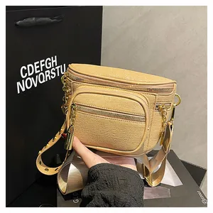 Dettagli di doppie cerniere e catena dorata su borsa a tracolla beige testurizzata