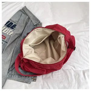 Interior detail of red nylon tote bag with ivory fabric lining and zip pocket