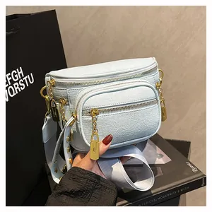 Dettaglio borsa a tracolla azzurra in pelle martellata con doppie cerniere dorate lucide