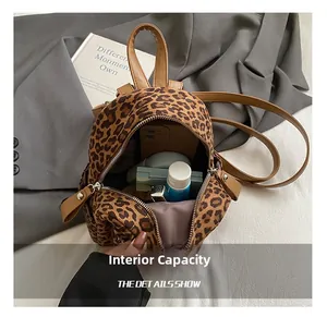 Detailed view of the leopard print backpack interior showing storage for phone and cosmetics