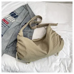 Macro detail of khaki nylon crossbody bag with drawstring design and cotton rope decoration