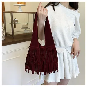 Vista macro di una borsa tote bordeaux in pelle scamosciata con frange a strati e stile hobo