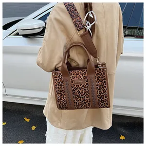 Detail der Handtasche mit Leopardenmuster, braunem Lederbesatz und breitem Gurt