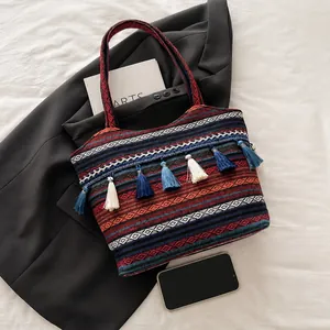Macro detail of bohemian jacquard woven patterns and colorful fringe on the shoulder bag