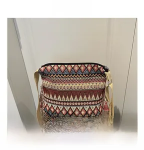 Close-up of bohemian jacquard crossbody bag with colorful tassels and ethnic geometric patterns