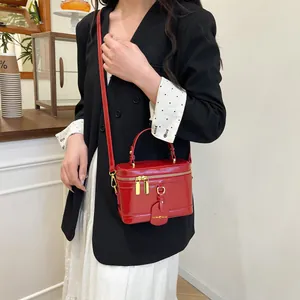 Borsa a mano strutturata in ecopelle rossa con tracolla in un ambiente caffè minimalista
