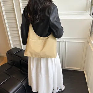 Sac fourre-tout demi-lune beige minimaliste avec texture carrée et poches multiples