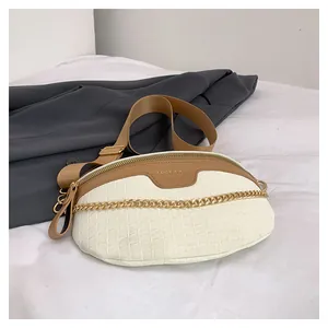 Détail du sac bandoulière blanc à motif croco avec chaîne dorée et large sangle brune