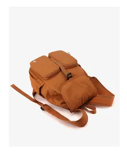 Dettaglio zaino marron in nylon con tasche frontali a zip e chiusura a fibbia
