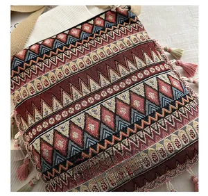 Detail showing the intricate bohemian woven pattern and colorful tassels of the crossbody bag