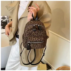 Detail shot of mini leopard print backpack with textured fabric and black leather strap