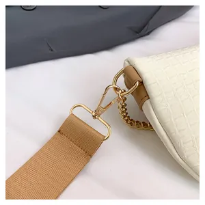 Détail du sac à motif crocodile crème avec quincaillerie dorée et large bandoulière