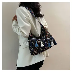 Dettaglio della borsa bohémien con motivi etnici geometrici e nappe colorate