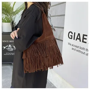 Dettaglio di una borsa tote in pelle scamosciata marrone scuro con frange stile bohémien