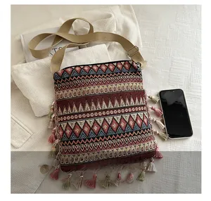 Detail of bohemian woven crossbody bag with geometric jacquard and colorful tassels