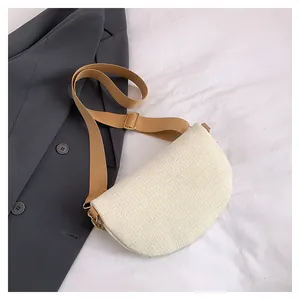 Détail du sac crème à motif crocodile avec chaîne dorée et bandoulière large tissée