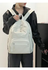Zaino puffer bianco in nylon impermeabile indossato con diverse tasche funzionali con zip