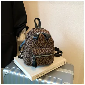 Detail of trendy leopard print mini backpack with black leather straps and silver zippers