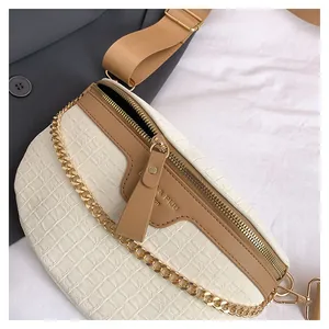 Détail de la texture crocodile blanc et de la bandoulière marron du sac de poitrine