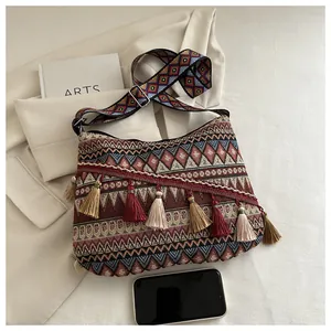 Dettaglio della borsa a tracolla jacquard boho con motivi geometrici e nappe colorate