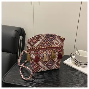 Vista dettagliata della borsa a secchiello jacquard boho con nappe colorate su tavolo
