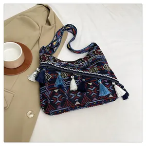 Dettaglio della borsa a tracolla boho con motivi etnici jacquard e decorazioni di nappe