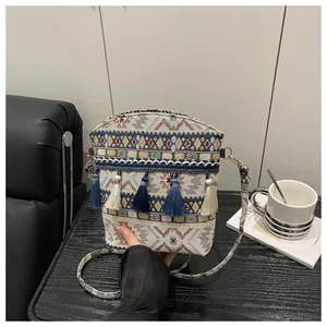 Dettaglio borsa a secchiello boho con trama jacquard e nappine colorate con frange