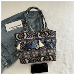 Dettaglio borsa tote in tela bohémien con motivo etnico e nappe colorate alla moda