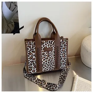 Detail der Handtasche mit Leopardenmuster und Lederflechtakzenten an der Seite
