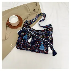 Dettaglio della borsa tote bohémien con nappe blu e motivi geometrici tessuti in stile etnico