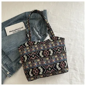 Borsa tote intrecciata in stile etnico con motivi geometrici su giacca di jeans