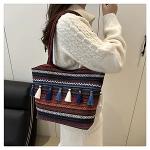 Dettaglio borsa a spalla bohémien con nappe etniche e motivi intrecciati in jacquard