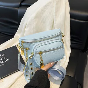 Borsa a tracolla azzurra a più strati con finiture dorate e tracolla ampia con borchie