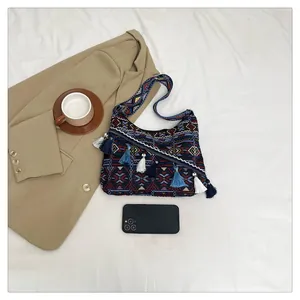 Dettaglio della borsa hobo etnica con motivi geometrici e nappe colorate