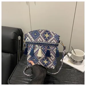 Dettaglio della borsa a secchiello jacquard boho con frange blu e motivi geometrici